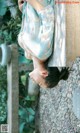 A woman in a blue kimono laying on a stone bench.