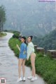 A couple of women standing next to each other on a road.