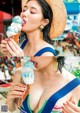 A woman in a straw hat eating an ice cream cone.