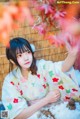 A woman in a kimono sitting in the snow.