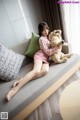 A woman sitting on a couch holding a teddy bear.