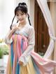 A woman in a colorful hanbok is posing for a picture.