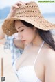 A woman wearing a straw hat on the beach.