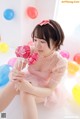 A young girl sitting on the floor holding a bunch of lollipops.